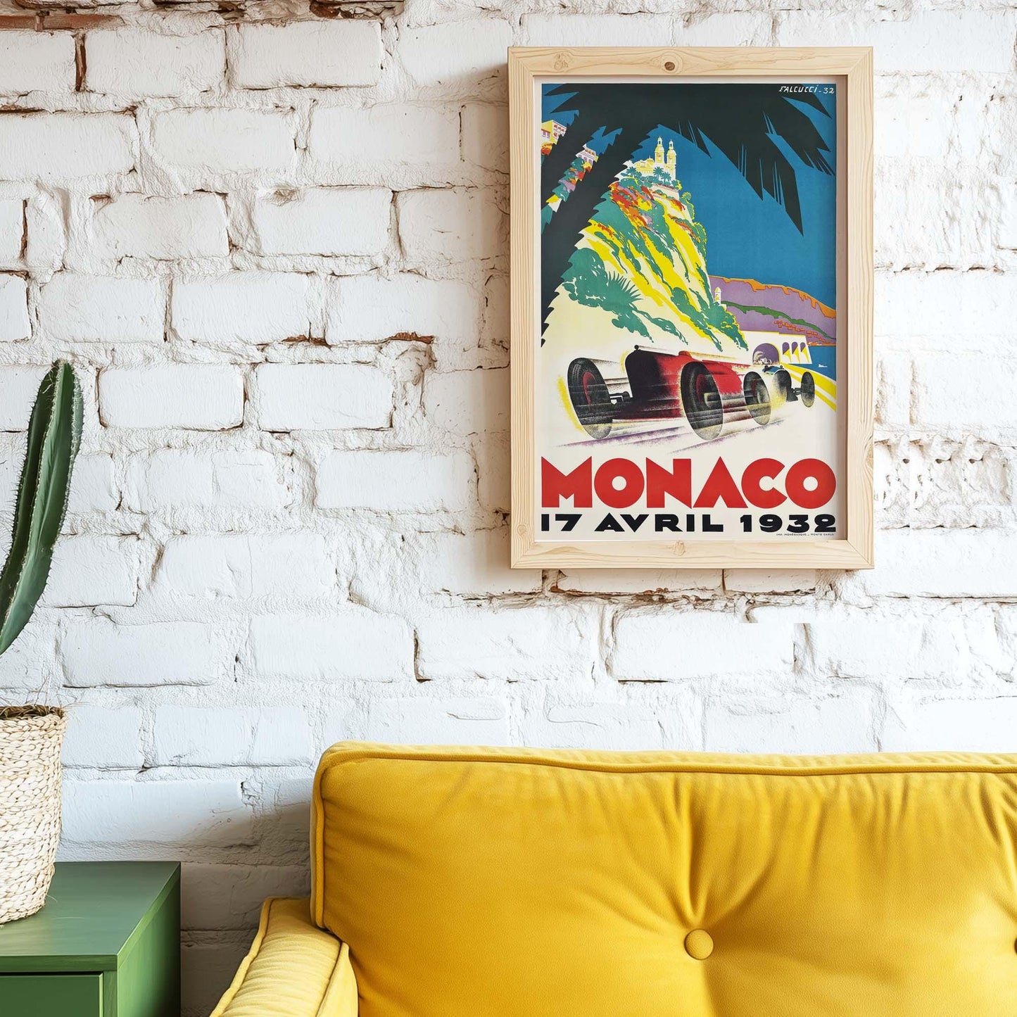 Vintage race poster aan witte muur van bakstenen. Ervoor staat een gele bank.