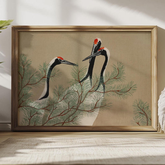 Japanse kraanvogels poster, ingelijst en staat tegen een lichte muur op een houten vloer.